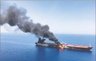  ?? Associated Press ?? An oil tanker is on fire in the sea of Oman on Thursday. Two oil tankers near the strategic Strait of Hormuz were reportedly attacked on Thursday, an assault that left one ablaze and adrift as sailors were evacuated from both vessels and the U.S. Navy rushed to assist amid heightened tensions between Washington and Tehran.