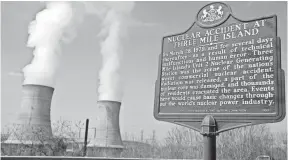  ?? AP FILE PHOTO ?? A historic marker is seen as the cooling towers of Three Mile Island’s Unit 1 Nuclear Power Plant pour steam into the sky in Middletown, Pa.