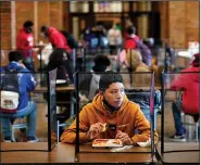  ?? (AP/Charlie Riedel) ?? Freshman Hugo Bautista eats lunch separated from classmates by plastic dividers at Wyandotte County High School in Kansas City, Kan., on March 31, the school’s first day of in-person learning.