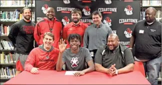  ?? Kevin Myrick ?? Coaches gathered with Zah Frazier for his signing day on Feb.21 with Southern Illinois. Heraised his hand as an inside joke.