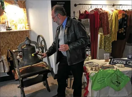  ?? MARK ROBARGE — MROBARGE@TROYRECORD.COM ?? Michael Barrett, executive director of the Hudson Mohawk Industrial Gateway rings a 150-year-old bell Wednesday during a ceremony to mark the opening of the holiday shopping season in downtown Troy at the Copper Fox, a clothing store on River Street.