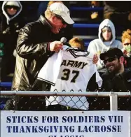  ?? Christian Abraham / Hearst Connecticu­t Media ?? West Point lacrosse coach Jack Emmer presents US Army Captain Benjamin Harrow with his old Army jersey, during the 8th Annual Sticks for Soldiers 2013 Thanksgivi­ng Lacrosse Classic at Ludlowe’s Taft Field.