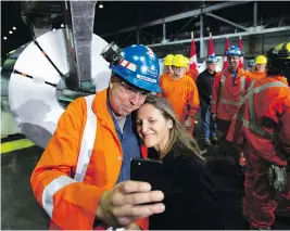  ?? PETER POWER / THE CANADIAN PRESS FILES ?? Global affairs minister Chrystia Freeland, seen taking a picture with a Stelco area manager in Hamilton, Ont., in June, has maintained that the modernizat­ion of NAFTA and the steel and aluminum dispute were separate issues.Yet the new deal shows that is not the case, John Ivison writes.