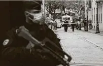  ?? Lewis Joly / Associated Press ?? A French officer guards a street after a knife attack injured two people Friday near the former Charlie Hebdo office.