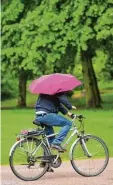  ?? Foto: dpa ?? Radler mit Regenschir­m könnten an Pfingsten öfter gesehen werden.