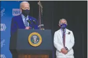  ?? (File Photo/AP/Evan Vucci) ?? President Joe Biden speaks during a visit to the Viral Pathogenes­is Laboratory at the National Institutes of Health, on Feb. 11 in Bethesda, Md. Dr. Anthony Fauci, director of the National Institute of Allergy and Infectious Diseases, listens at right.