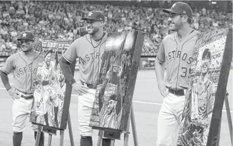  ?? Melissa Phillip photos / Houston Chronicle ?? Astros Jose Altuve, left, George Springer, center, and Justin Verlamder pose with their portraits by artist Opie Otterstad, which were presented during pregame ceremonies before Friday night’s game against San Diego.