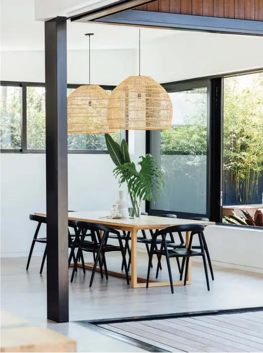  ??  ?? ABOVE The family’s American ash dining table was custom-made by WRW & Co and teamed with Maki chairs from St Clements. Overhead are Wicker Hanging Lamps by HK Living from Nest Direct.