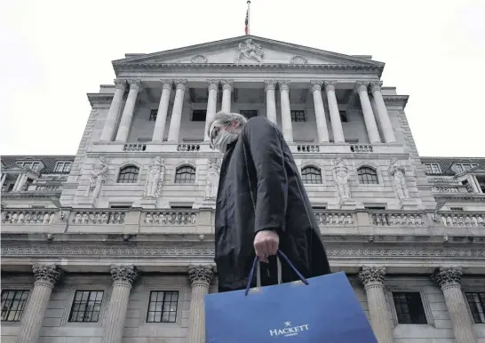  ?? TOBY MELVILLE ■ REUTERS ?? A man walks past the Bank of England building in London.