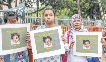  ?? AFP ?? Women hold placards with a photograph of Nusrat Jahan Rafi at a protest in Dhaka in April following her murder after she was set on fire for reporting sexual assault.