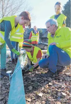  ?? FOTO: ELKE OBERLÄNDER ?? Ulfried Miller vom BUND Ravensburg zeigt Schülern der Gemeinscha­ftsschule Horgenzell, wie sie den Amphibienz­aun gut abdichten.