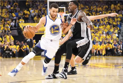  ??  ?? Golden State Warriors guard Stephen Curry dribbles the basketball against San Antonio Spurs center Dewayne Dedmon during the first quarter in Game 2 of the Western Conference finals of the NBA Playoffs at Oracle Arena on Tuesdya. (USA TODAY Sports)