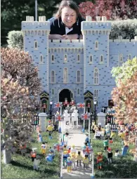  ?? PICTURE: REUTERS/PETER NICHOLLS/ANA ?? Head model-maker Paula Laughton poses for a photograph with a Lego Windsor Castle replete with royal wedding between Britain’s Prince Harry and Meghan Markle, in Windsor on Thursday.