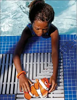  ?? Katharine Lotze/The Signal (See additional photos at signalscv.com) ?? Jade McWilson, 6, plays with a Finding Nemo toy during the World’s Largest Swimming Lesson at the Santa Clarita Aquatic Center on Thursday.