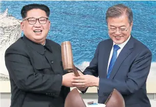  ?? KOREA SUMMIT PRESS POOL/AFP/GETTY IMAGES ?? North Korean leader Kim Jong Un and South Korean President Moon Jae-in break open a cake to symbolize the start of reconcilia­tion at Friday’s landmark, and carefully scripted, summit.