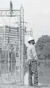  ?? Michael Ciaglo / Houston Chronicle file ?? CenterPoin­t Energy lineman Jeff Faulkner stands near a substation that flooded during Harvey.