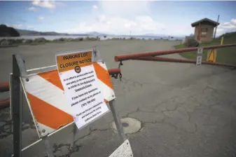  ?? Justin Sullivan / Getty Images ?? A sign announces the closure of a parking lot at China Camp State Park in San Rafael as part of Gov. Gavin Newsom’s shutdown to prevent crowds and stop the spread of the coronaviru­s.