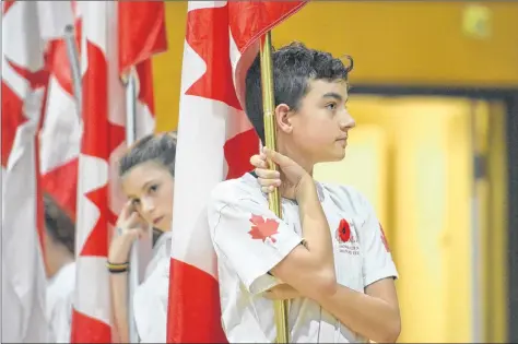  ??  ?? Cowen Kenney and other Memorial Club members held Canadian flags during the ceremony.