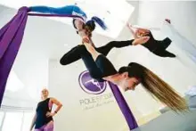  ?? A.K. Kallouche/Gulf News Archives ?? Instructor­s at Pole Fit Dubai teach women — and men — of all ages and sizes how to wrap themselves around a pole, or silks suspended from the ceiling.