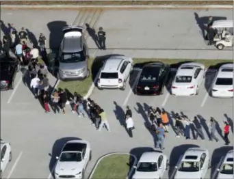  ?? ASSOCIATED PRESS ?? Students are evacuated by police from Marjory Stoneman Douglas High School in Parkland, Fla., on Feb. 14 after a shooter opened fire on the campus.