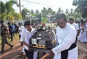  ?? JEWEL SAMAD/AFP/GETTY IMAGES ?? Priests and relatives carry the coffin of a bombing victim after a service Tuesday at St. Sebastian’s Church in Negombo, Sri Lanka.