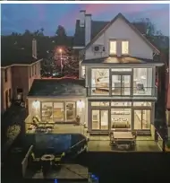  ??  ?? The windows that cover the back of the house offer spectacula­r views of Downtown Pittsburgh.
Left: The front of the house is very traditiona­l, with Italianate and Queen Anne details
Top: The view at twilight from the upper deck at 427 Bailey Ave., Mount Washington.