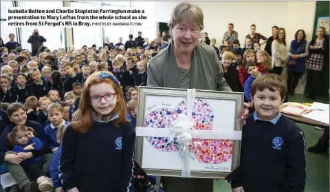  ?? PHOTOS BY BARBARA FLYNN ?? Isabelle Bolton and Charlie Stapleton Farrington make a presentati­on to Mary Loftus from the whole school as she retires from St Fergal’s NS in Bray.