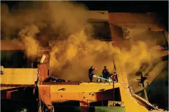  ?? Bilal Hussein/associated Press ?? Smoke rises from a destroyed apartment building as civil defense workers search for survivors following a massive explosion Tuesday in the southern Beirut suburb of Dahiyeh, Lebanon.