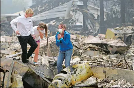  ?? JEFF CHIU/AP PHOTO ?? Mary Caughey, right, reacts with her son Harrison, left, after finding her wedding ring Tuesday in debris at her home destroyed by fires in Kenwood, Calif.