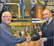  ?? 25_c53retirem­ent01 ?? Master distiller Jim Grogan receives a quaich and bottle of very special Glen Scotia on his retirement from his boss Iain McAlister.