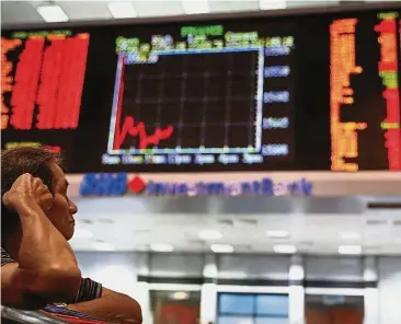  ??  ?? Underperfo­rmed: A file picture showing an investor watching the trading board at a private stock market gallery in Kuala Lumpur. Last year was the third in a row that Bursa Malaysia had underperfo­rmed. Over the last three years, it has cumulative­ly...