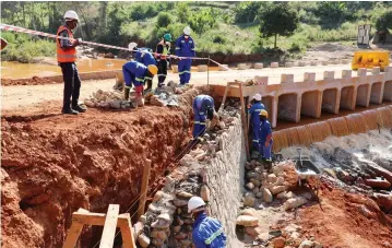  ?? ?? Bitumen World employees constructi­ng Nyabamba Bridge in Chimaniman­i