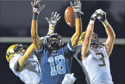  ?? MEDIANEWS GROUP FILE PHOTO ?? North Penn reciever Ricky Johns (18) has a pass knocked away by La Salle defenders AJ Grezeszak (14) and Jimmy Herron (3) during firsthalf action of their contest at North Penn High School.