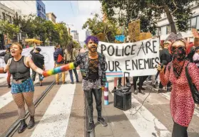  ?? Gabrielle Lurie / The Chronicle 2019 ?? Indigo Cochran (left), Zedgar Infiniti and others try to shut down the annual Pride Parade on San Francisco’s Market Street in June. Law enforcemen­t’s relationsh­ip with the LGBTQ community has long been fraught.