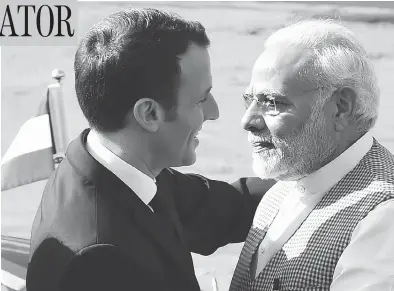  ?? MONEY SHARMA/AFP/GETTY IMAGES ?? India’s Prime Minister Narendra Modi, right, greets France’s President Emmanuel Macron upon his arrival at the Presidenti­al Palace in New Delhi on Saturday — a welcome that sharply contrasted the cool one given Justin Trudeau.