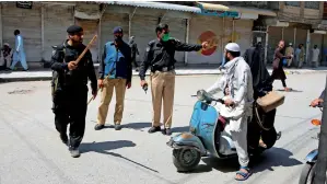  ?? AP ?? NO MOVEMENT: Police officers try to enforce a lockdown in Peshawar on Tuesday as part of measures to curb the spread of coronaviru­s. —