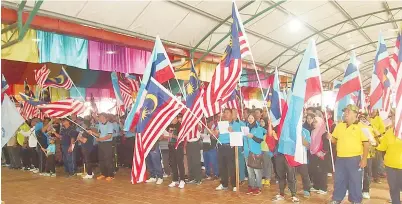  ??  ?? SEBAHAGIAN orang ramai yang menghadiri sambutan itu sambil menyanyika­n Jalur Gemilang.