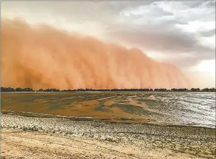  ??  ?? Rochelle Karsten’s incredible picture of a massive dust cloud moving towards Gum Bend Lake at Condobolin.