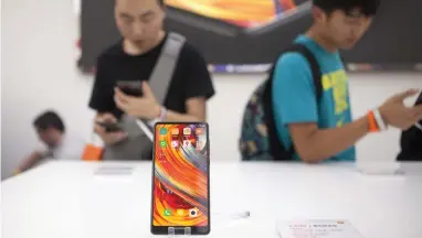  ?? Bloomberg ?? A Xiaomi Mi Mix 2 smartphone on display in Beijing. Xiaomi aims to roll out phones in the US within two years. —