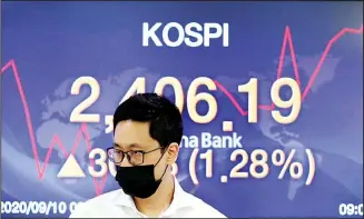  ??  ?? A currency trader walks by the screen showing the Korea Composite Stock Price Index (KOSPI) at the foreign exchange dealing room in Seoul, South Korea on Sept 10. Asian stock markets gained Thursday after Wall Street
rebounded from a three-day slump for tech stocks. (AP)