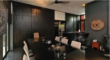  ?? PICTURES: SAMUEL ISAAC CHUA/THE EDGE SINGAPORE ?? The dining room and dry kitchen with concealed storage space and entrance to the wet kitchen and helper’s quarters behind the black panelling