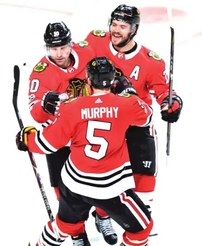  ?? | PAUL BEATY/ AP ?? Patrick Sharp ( 10) celebrates with Brent Seabrook ( 7) and Connor Murphy after scoring in the first period.