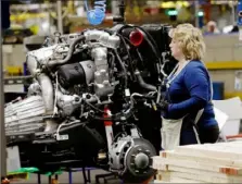  ?? Jeff Kowalsky/AFP via Getty Images ?? A line employee works on the chassis of full-size General Motors pickup trucks at the Flint Assembly plant in 2019 in Flint, Mich. General Motors reported higher first-quarter profits Wednesday, reporting 10 times the level in the year-ago period, on strong vehicle pricing.