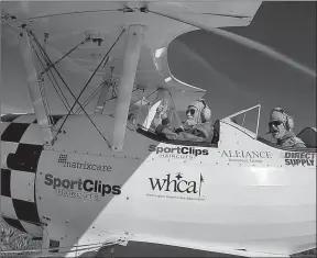  ?? Tribune News Service ?? World War II pilot Robert Capen gives a thumbs-up to pilot Darryl Fisher during a flight provided by Fisher’s Ageless Aviation Dreams Foundation.