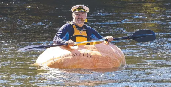  ?? ?? John Farquharso­n sailed a massive award-winning 407-kilogram gourd grown by Mark Peacock down a river.