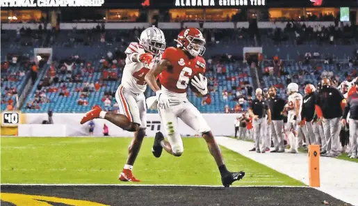  ?? KIM KLEMENT/USA TODAY SPORTS ?? DeVonta Smith scores a touchdown ahead of Ohio State safety Josh Proctor during the College Football Playoff national championsh­ip game at Miami Gardens. “We don’t stop,” Smith said. “We just keep reloadin’.”