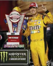  ?? STEVE HELBER — THE ASSOCIATED PRESS ?? Kyle Busch poses with the winners trophy in Victory Lane after winning the NASCAR Cup Series auto race at Richmond Raceway Saturday. Busch pulled away on a restart in a two-lap overtime sprint to the finish for his third straight Sprint Cup Series win.
