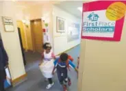  ??  ?? Twins Deborah, left, and Petros Kahssay, 8, walk through a hallway at First Place Scholars Charter School, in June 2014 in Seattle. The school was Washington’s first charter school, but it later reverted back to being a private school.