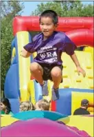  ??  ?? Jake Tan, 5, of Lower Gwynedd, bounces on one of the amusements.