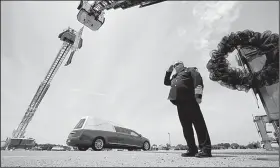  ?? Arkansas Democrat-Gazette/STATON BREIDENTHA­L ?? Batesville Fire Chief Brent Gleghorn salutes Friday in Newport as the hearse carrying Newport police Lt. Patrick Weatherfor­d passes under a flag hung between ladder trucks from the Batesville and Newport fire department­s.